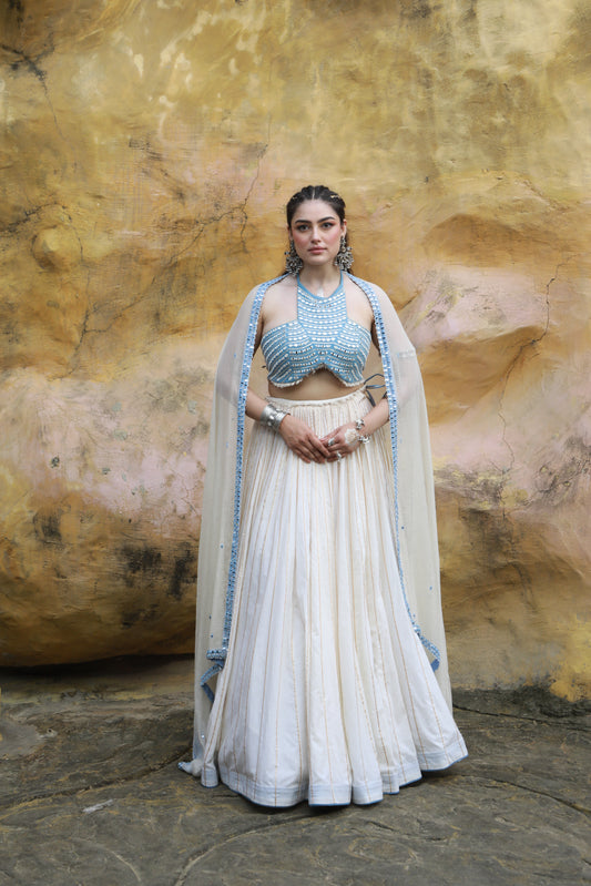 DEVI DRAPE IVORY MAL LEHANGA WITH DENIM HALTER NECK EMBELLISHED BLOUSE AND IVORY KOTA DORIA EMBELLISHED DUPATTA