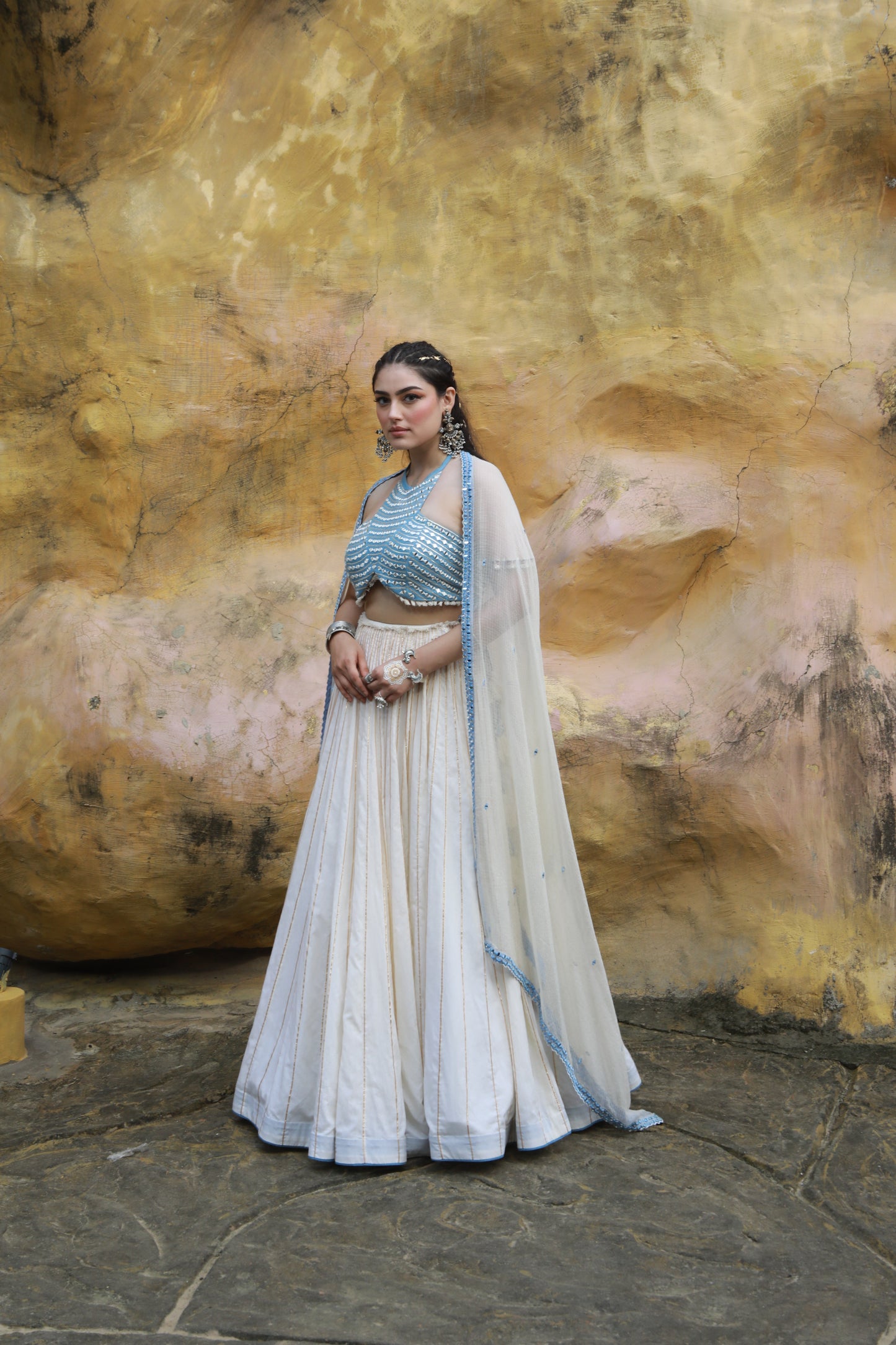 DEVI DRAPE IVORY MAL LEHANGA WITH DENIM HALTER NECK EMBELLISHED BLOUSE AND IVORY KOTA DORIA EMBELLISHED DUPATTA