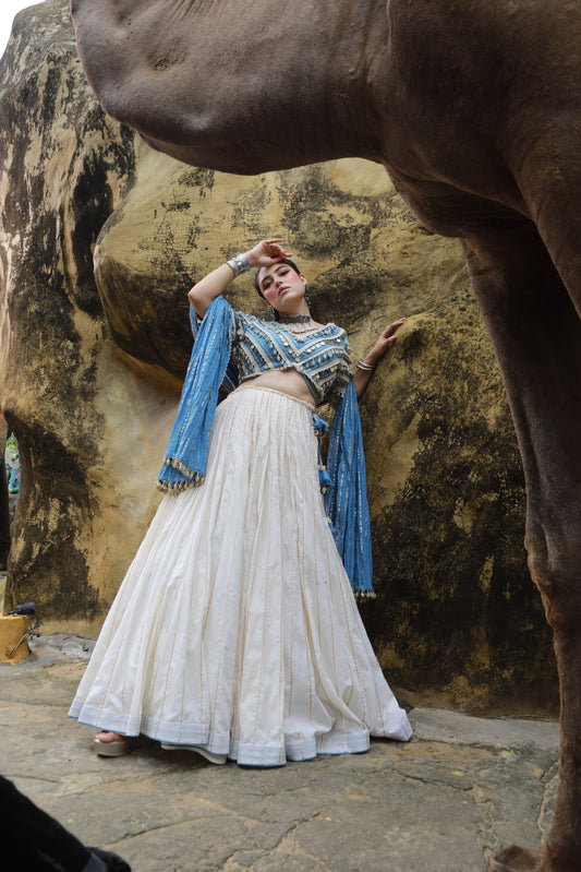 DEVI DRAPE IVORY MAL LEHANGA WITH DENIM LACE EMBELLISHED BLOUSE AND DENIM BLUE CRUSHED DUPATTA